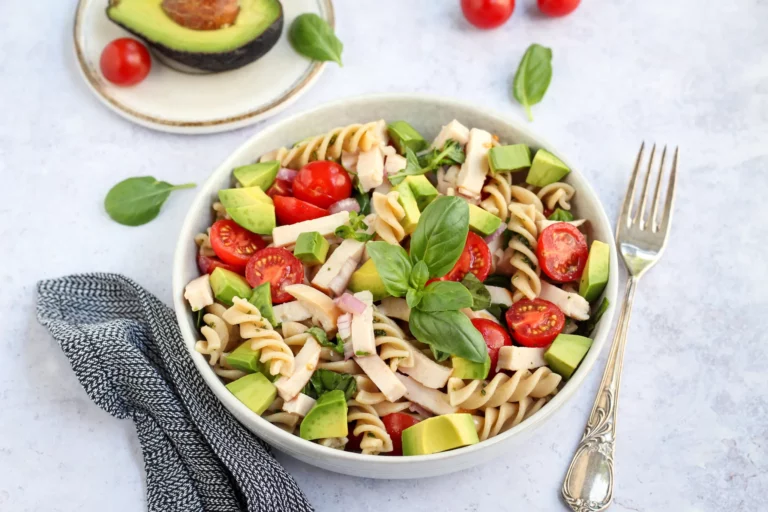 Chicken avocado pasta salad with cherry tomatoes and fresh basil