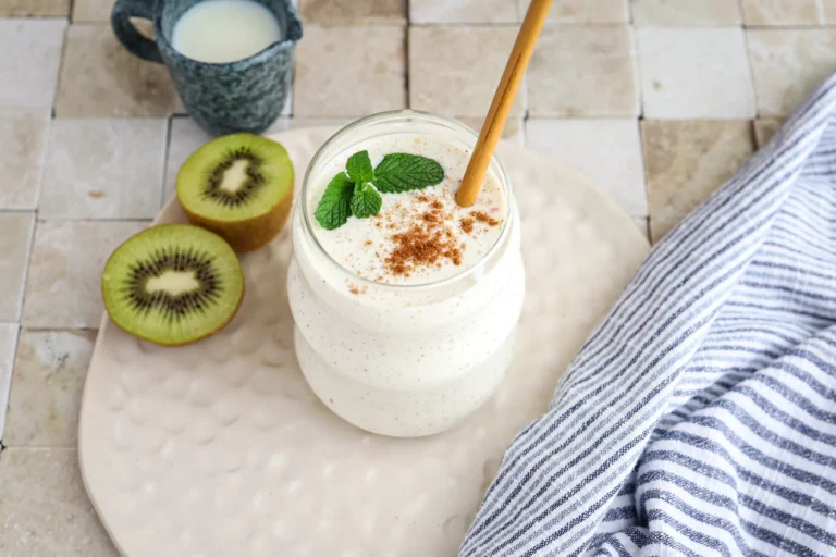 Creamy apple and kiwi breakfast smoothie in a glass jar.